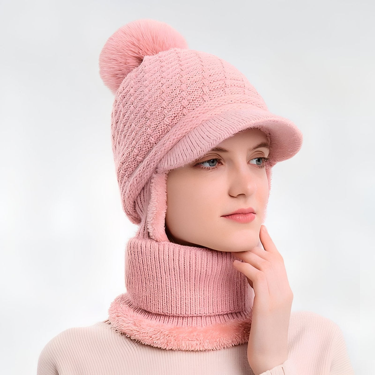 Woman wearing the powder pink brim beanie with ear flaps and neck warmer