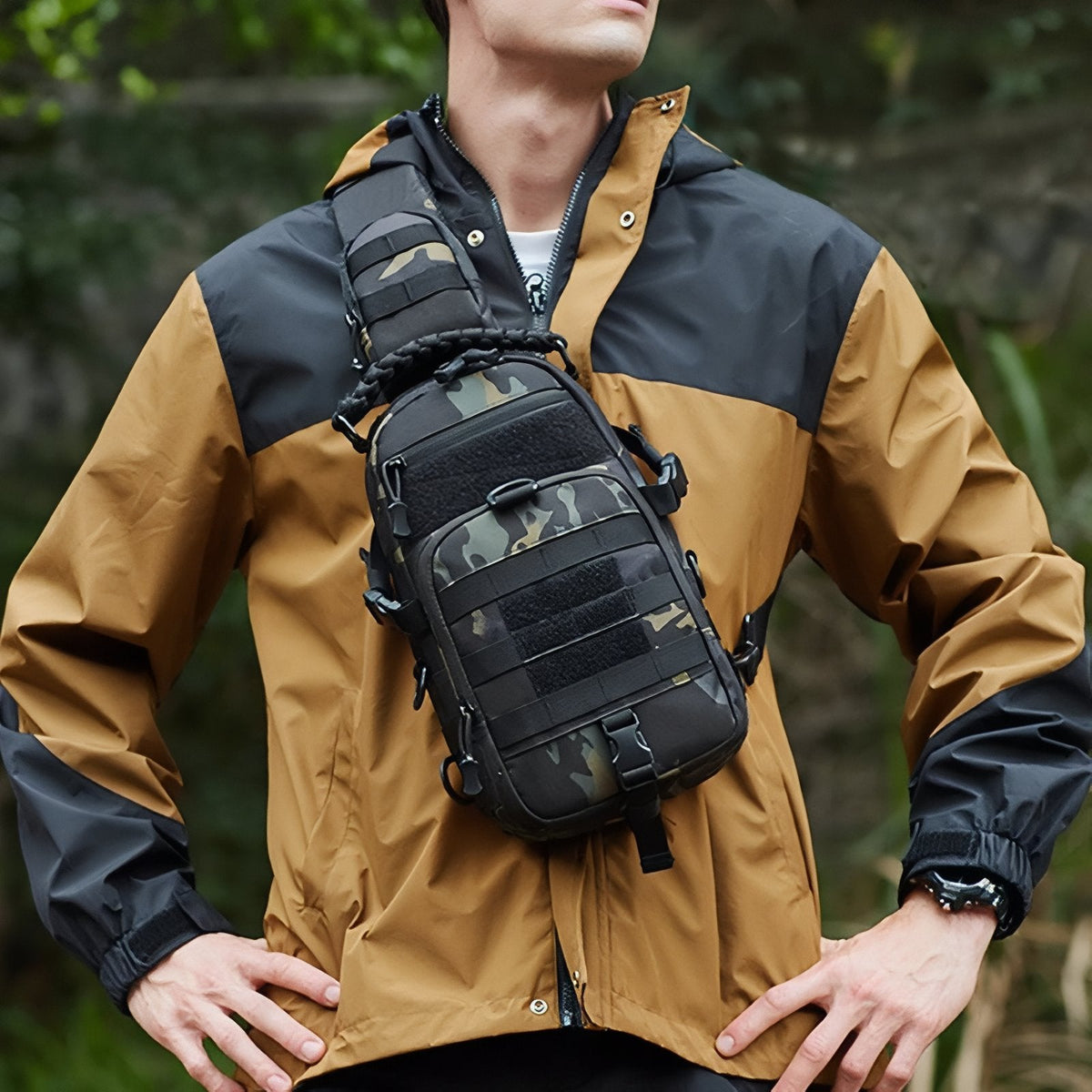 Man wearing the black camouflage sling bag across his chest over an orange jacket