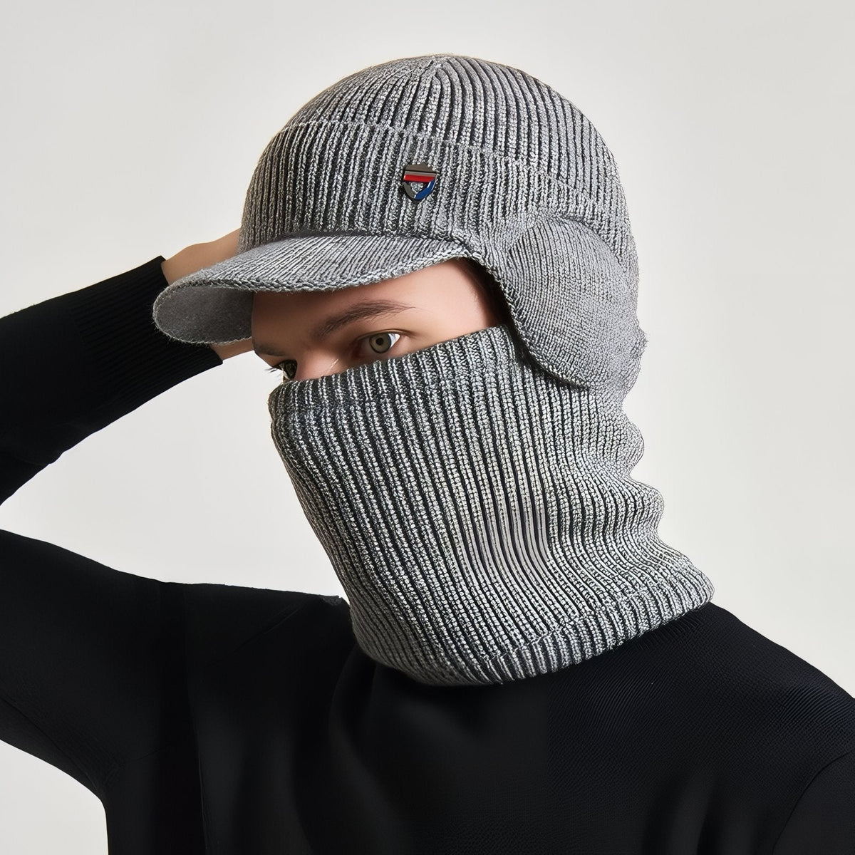 Man wearing the light grey hat with the neck warmer pulled up over his nose