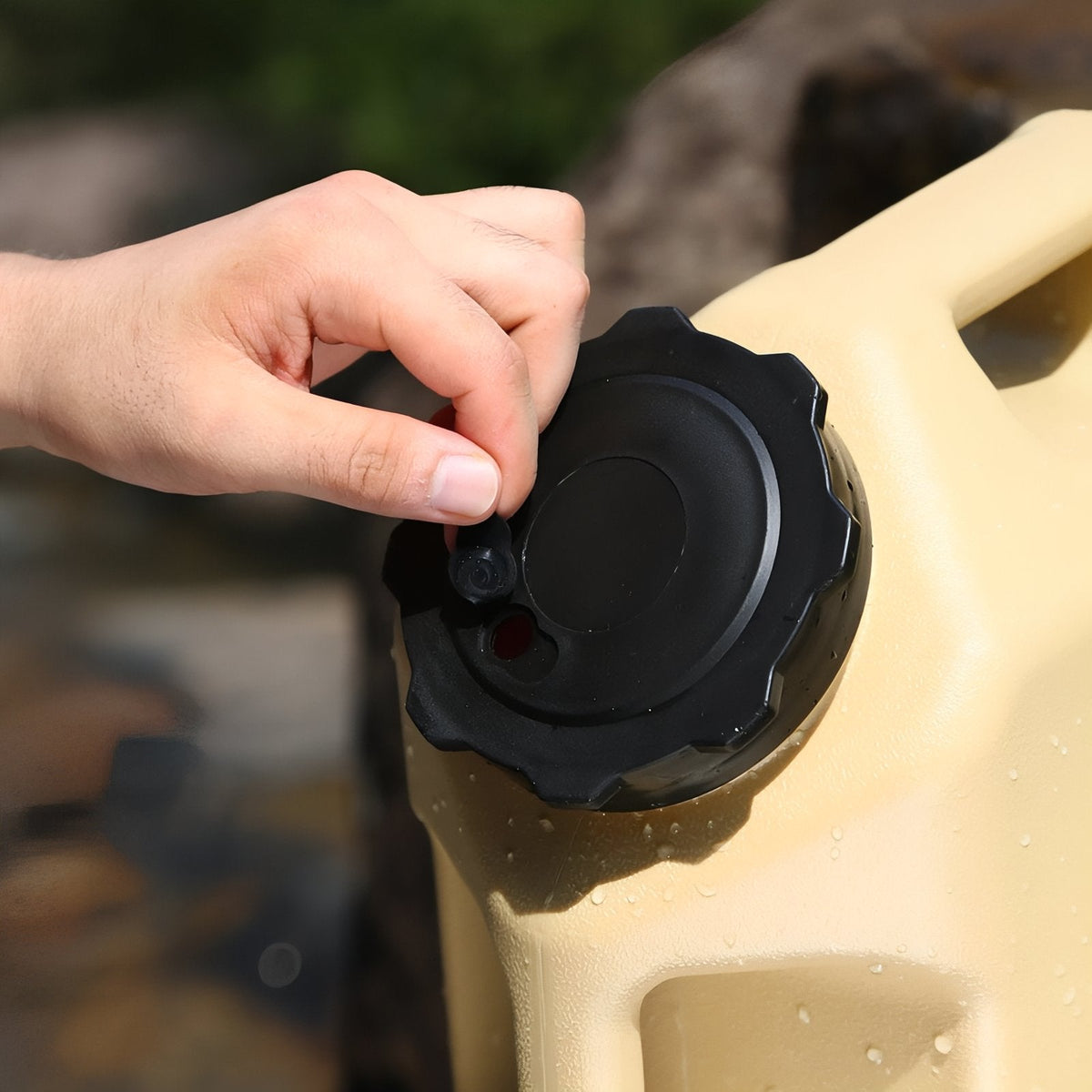 Hand screwing the black cap onto the container