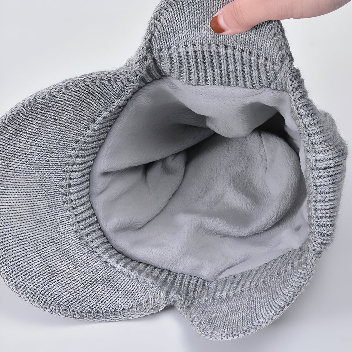 Inside of the light grey beanie showing the soft grey plush lining