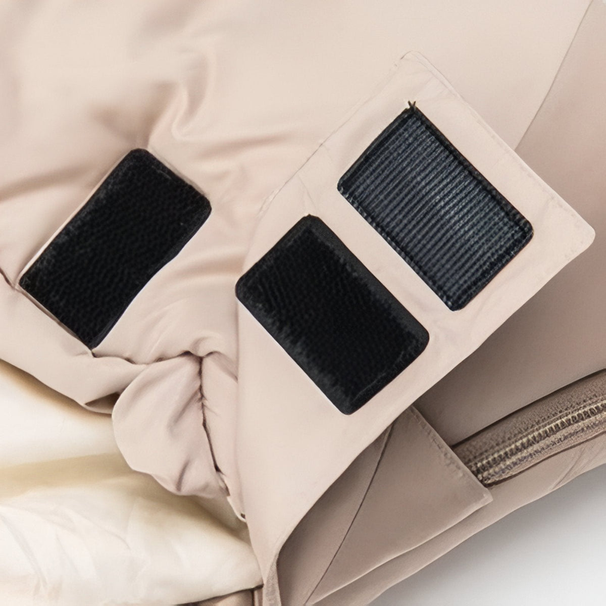 Close-up of the black hook-and-loop tabs that hold the top of the sleeping bag's zip closed