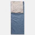 A light blue envelope sleeping bag laid flat, its cream lining folded back at the head