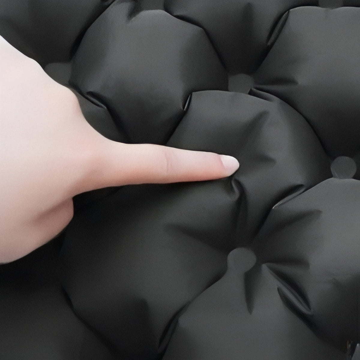 Finger pressing into an air cell of the charcoal cushion