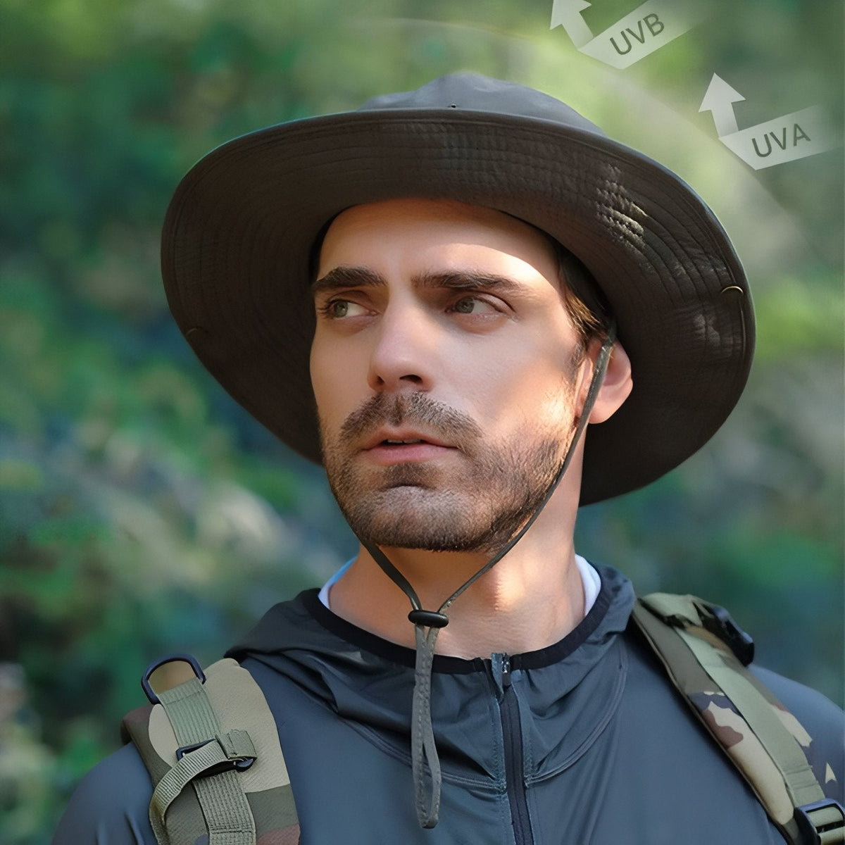 Man in the forest wearing the dark wide brim hat with the chin strap fastened, sun arrows marked UVA and UVB