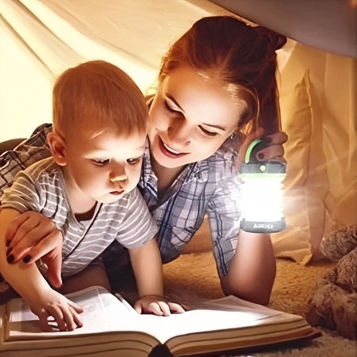 A mother and child reading by the light of the collapsible lantern in a tent