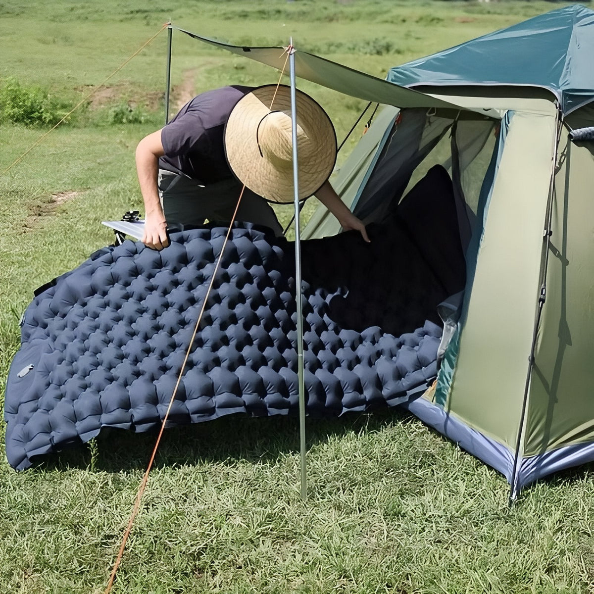 Charcoal grey sleeping mat being laid into a tent