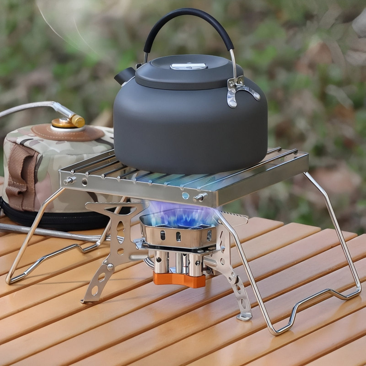 A kettle on the grill stand over a lit gas stove