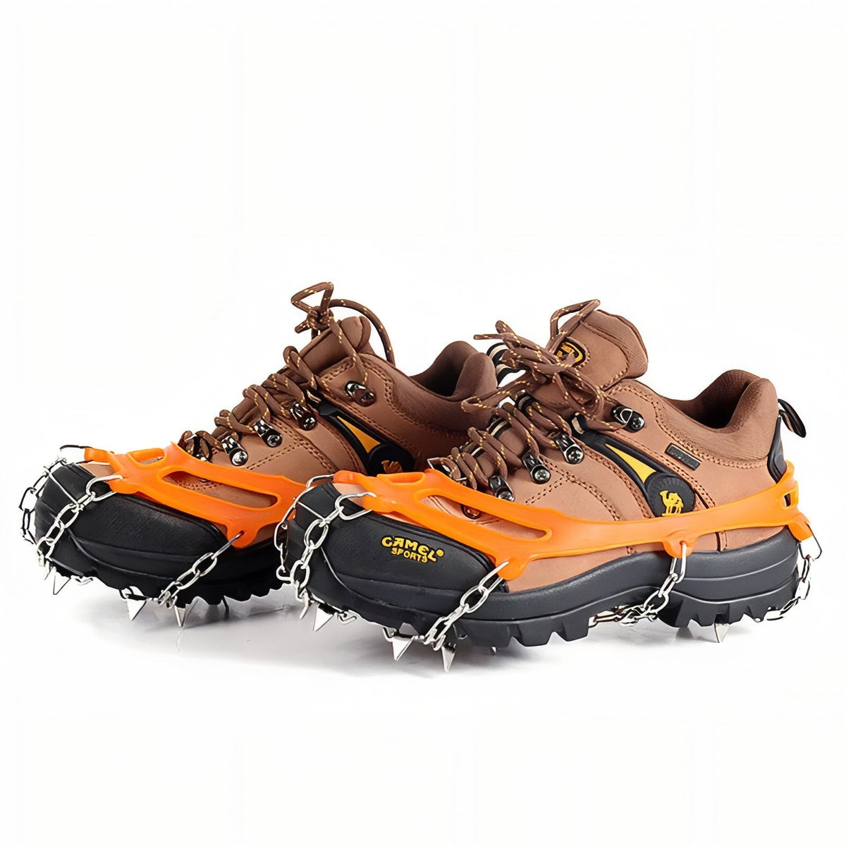 Pair of orange chain crampons fitted over brown hiking boots, seen from the side