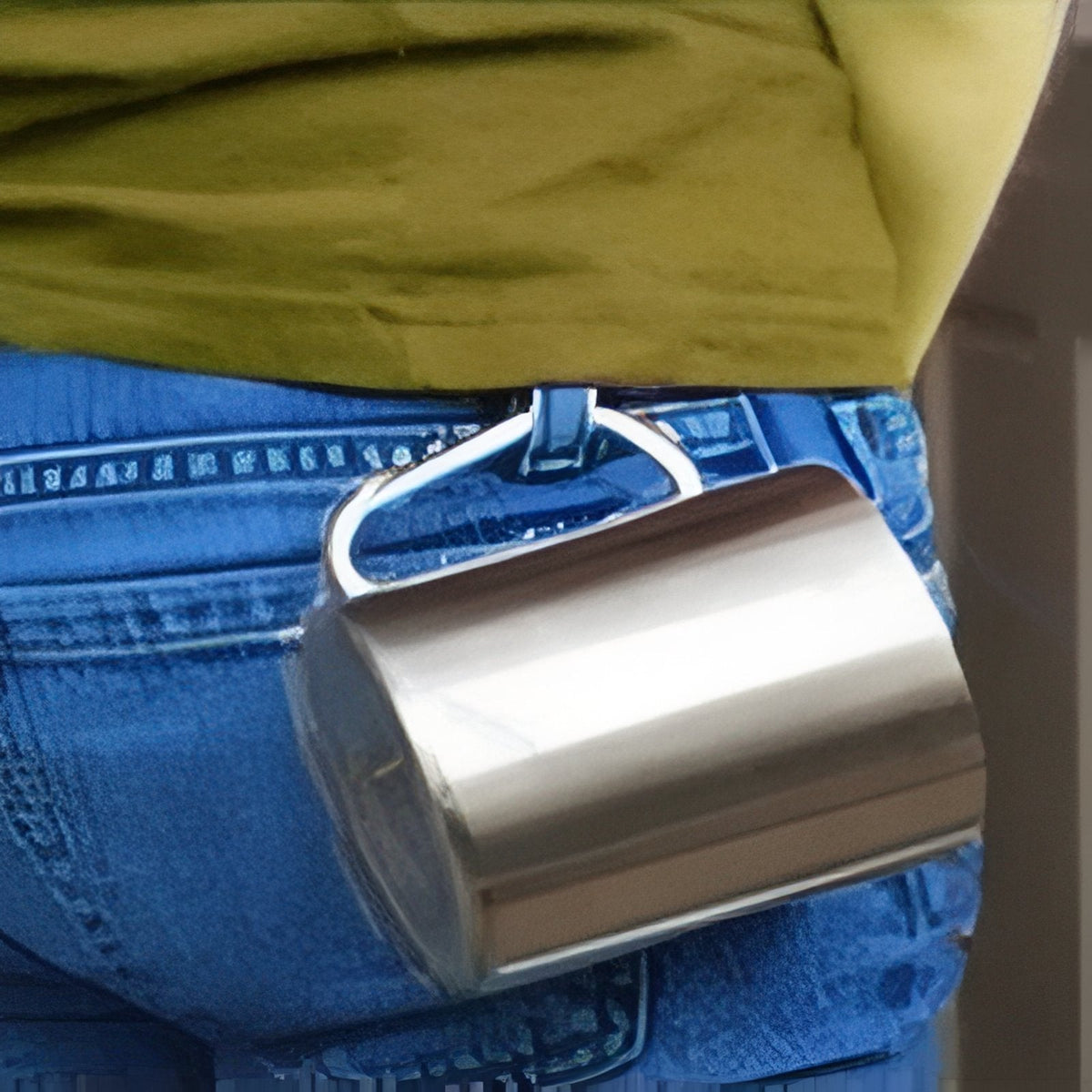 Stainless steel mug clipped by its carabiner to the belt loop of a pair of jeans