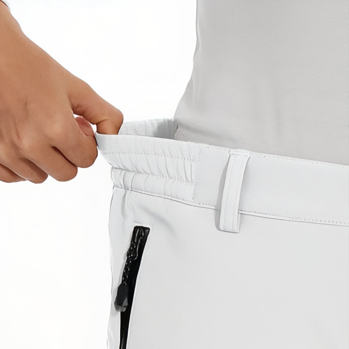 Hand stretching the elastic back of the waistband on the white trousers
