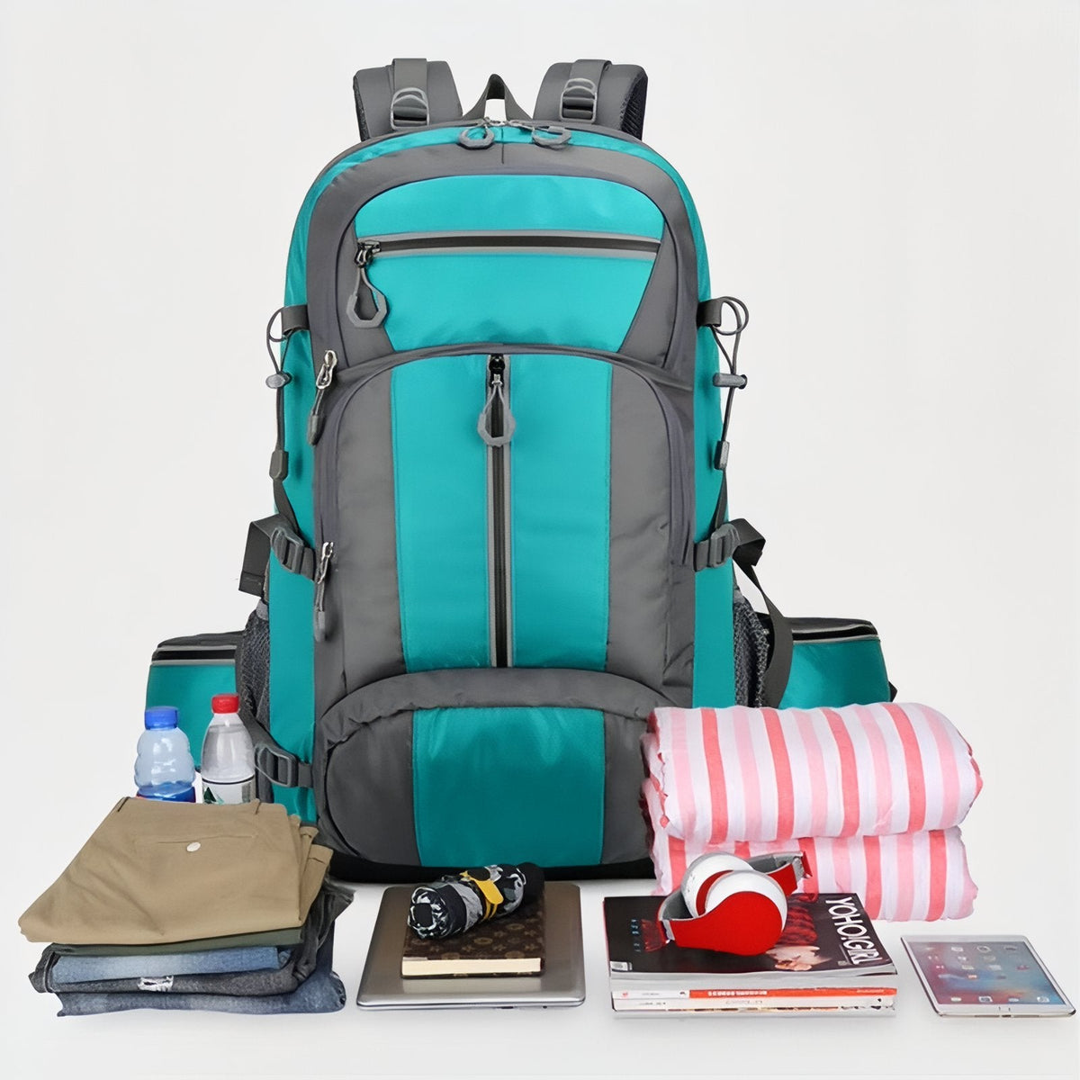 Turquoise backpack with the clothes and gear it holds laid out in front