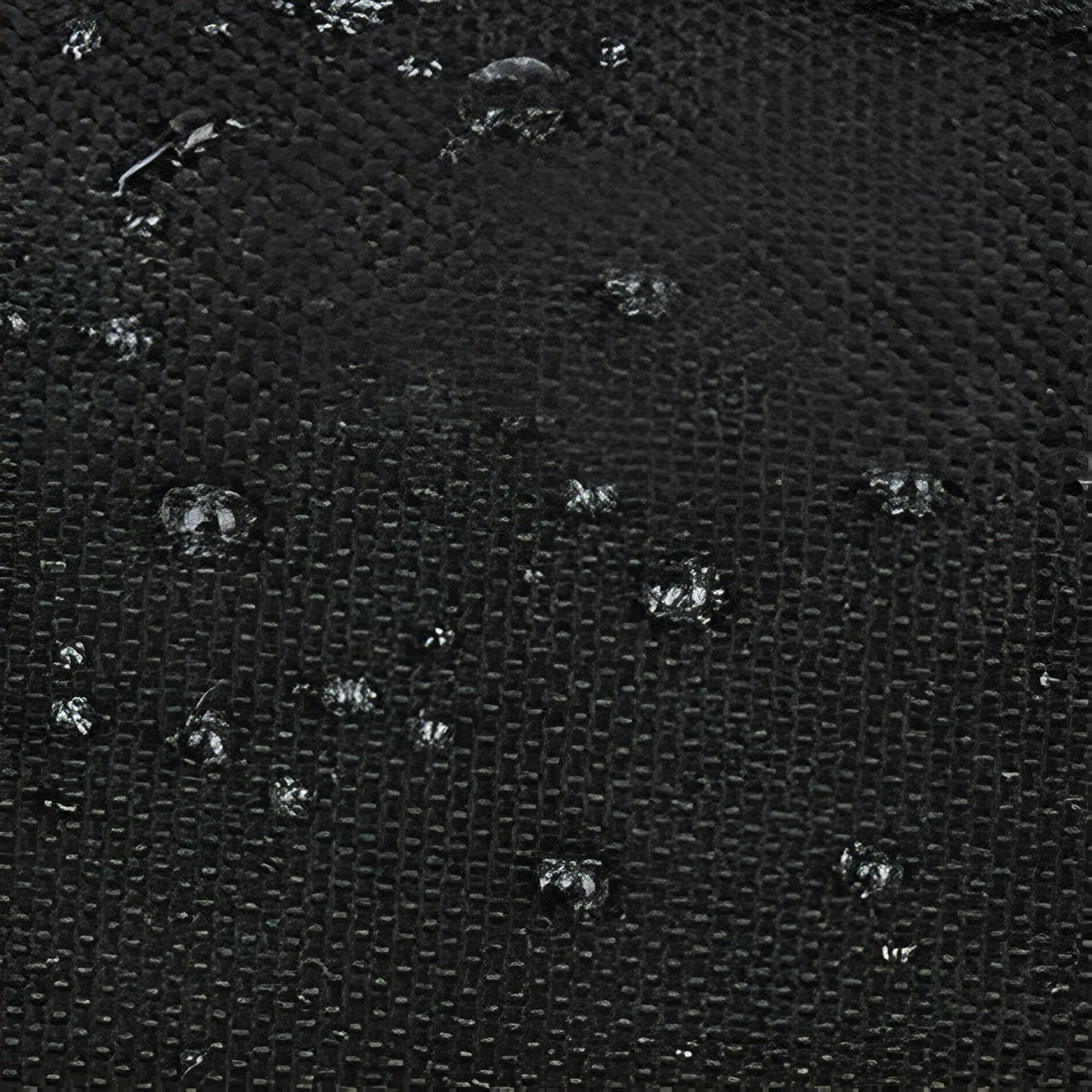 Close-up of the black woven fabric with water drops on it