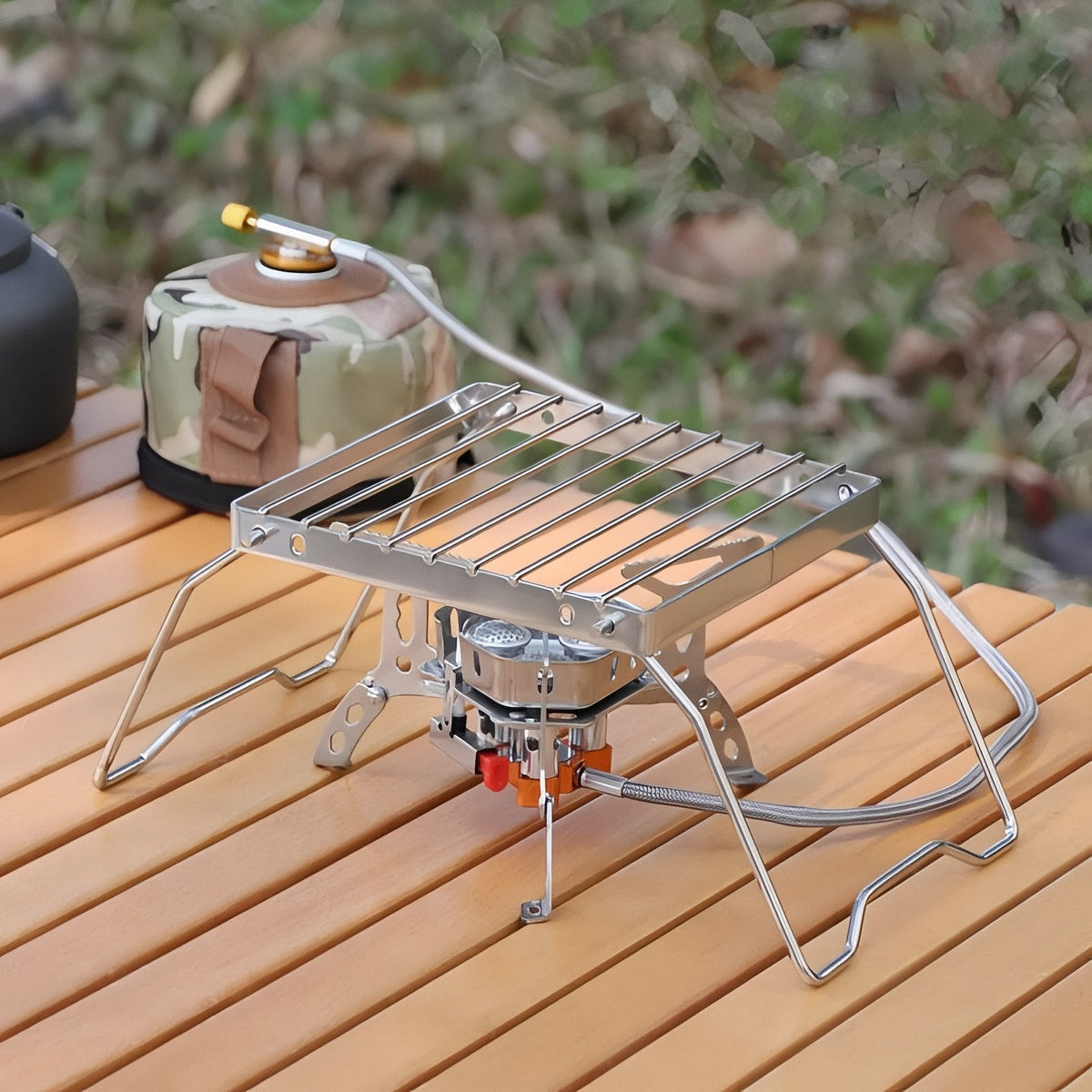The grill stand over a small gas stove on a wooden camp table