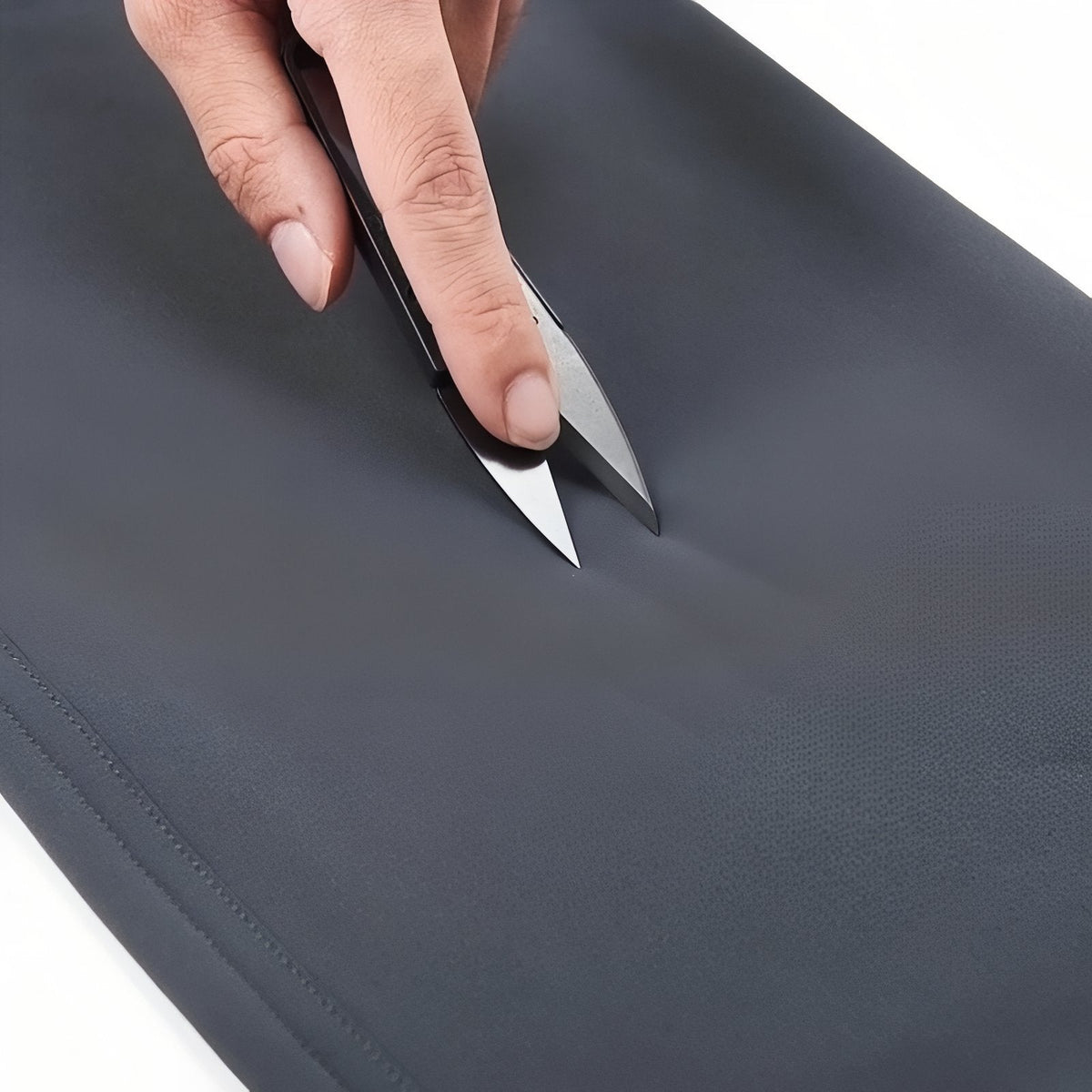 Close-up of the slate grey softshell fabric pressed with a blade tip