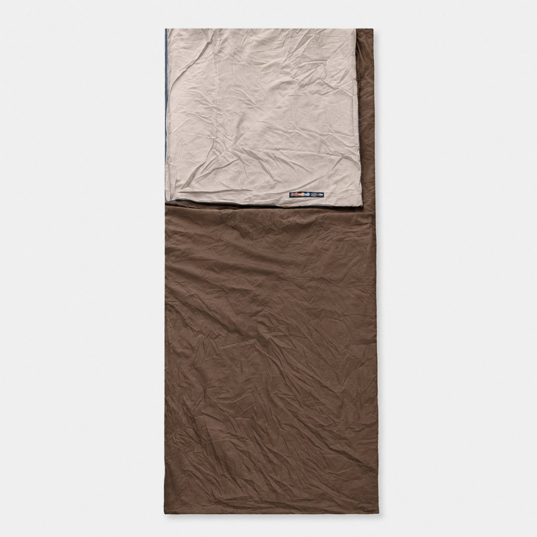 A brown envelope sleeping bag laid flat, its beige lining folded back over the top third