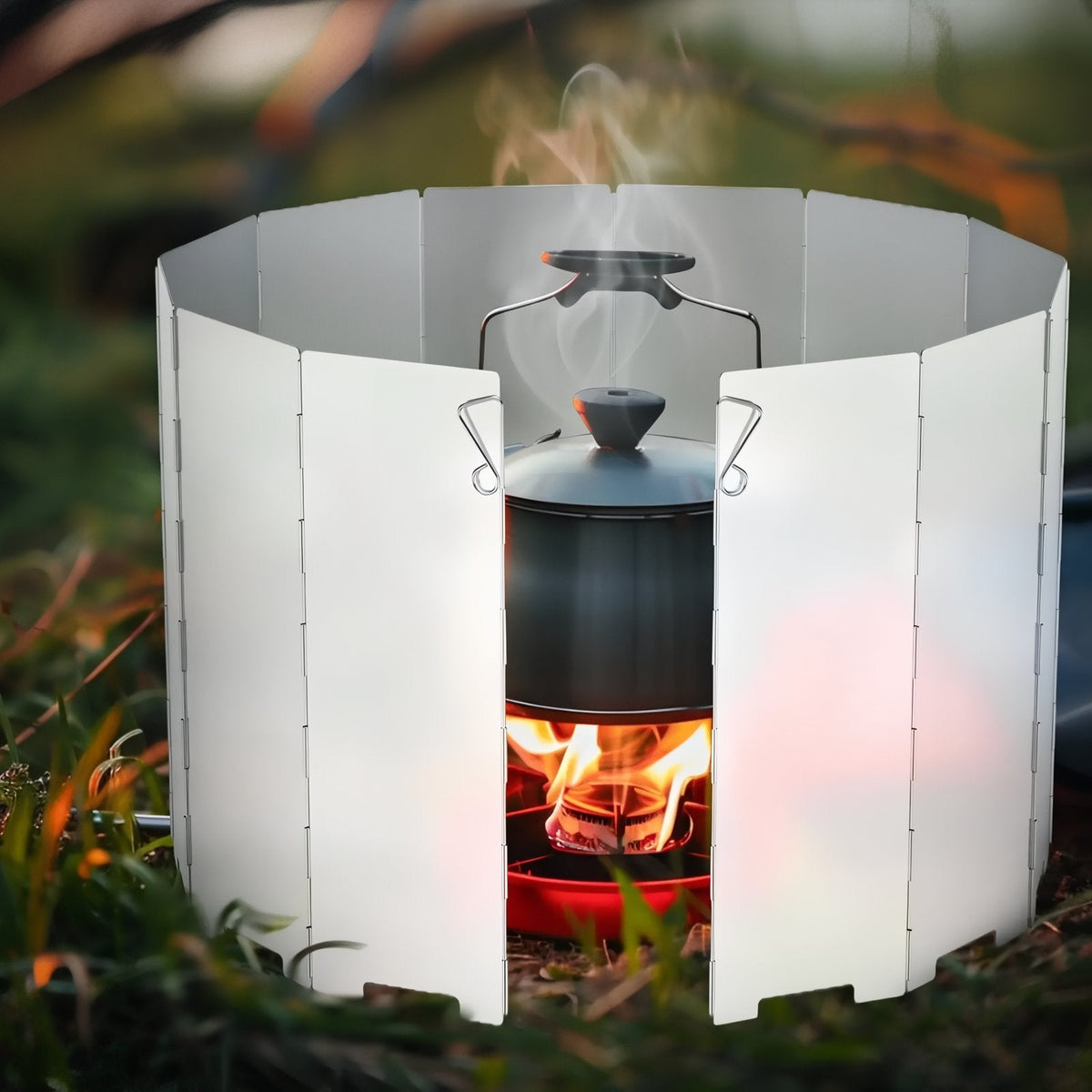 Windscreen ringed round a steaming kettle on a burner outdoors