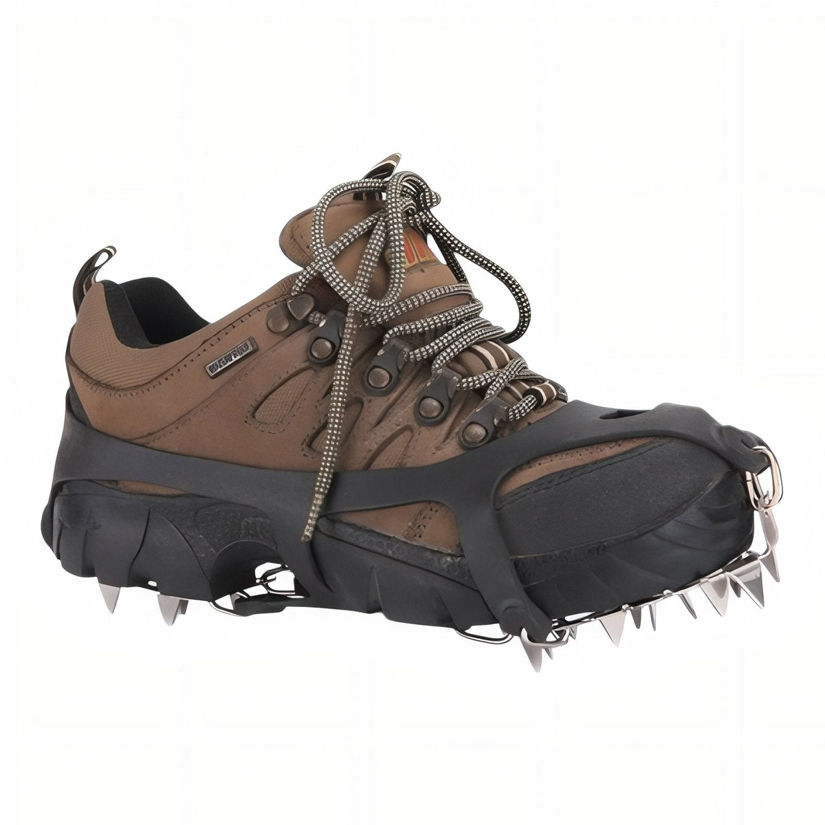 Black slip-on crampon stretched over a brown hiking shoe, steel spikes under the toe and heel