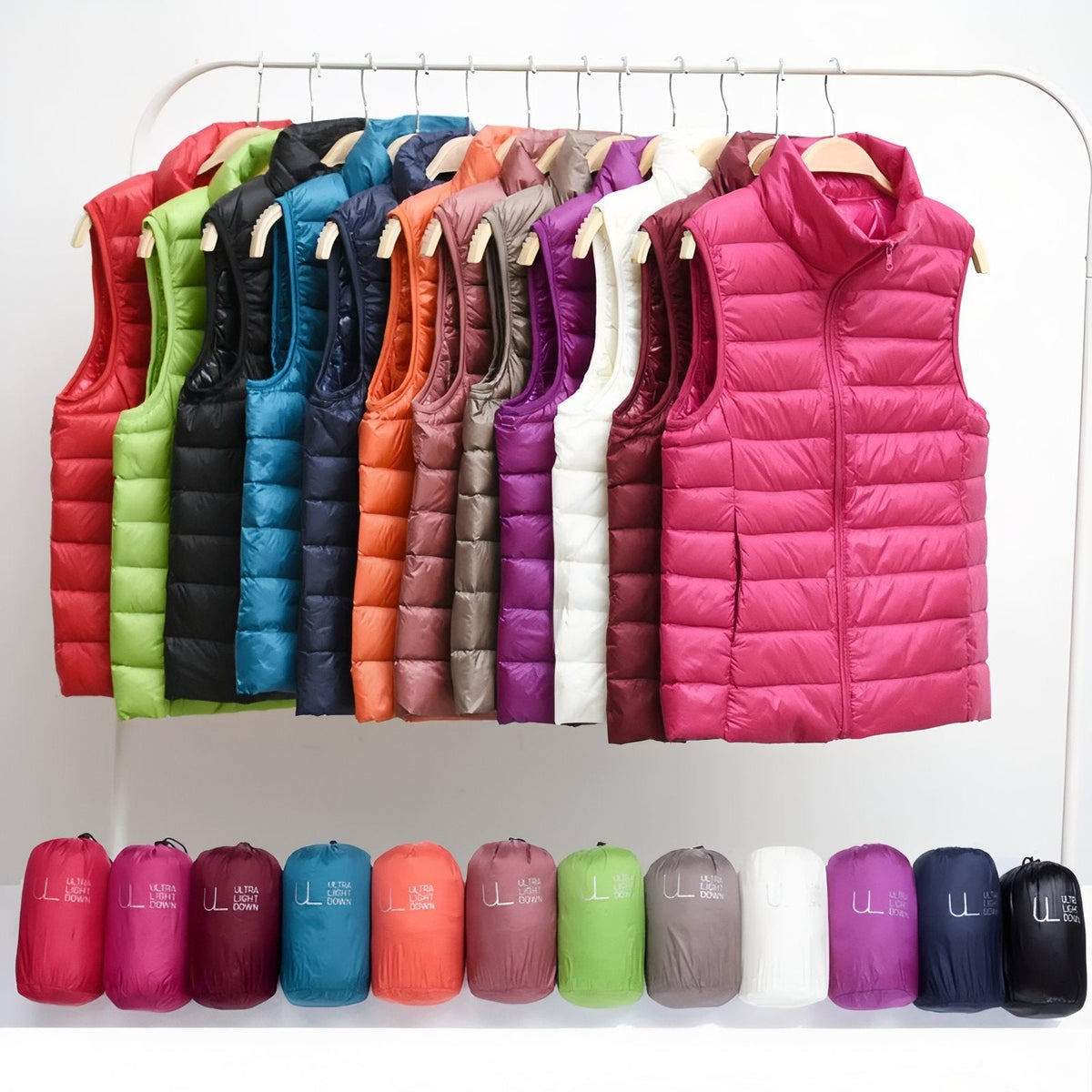 Quilted vests in many colours on a clothes rail above their packed bags