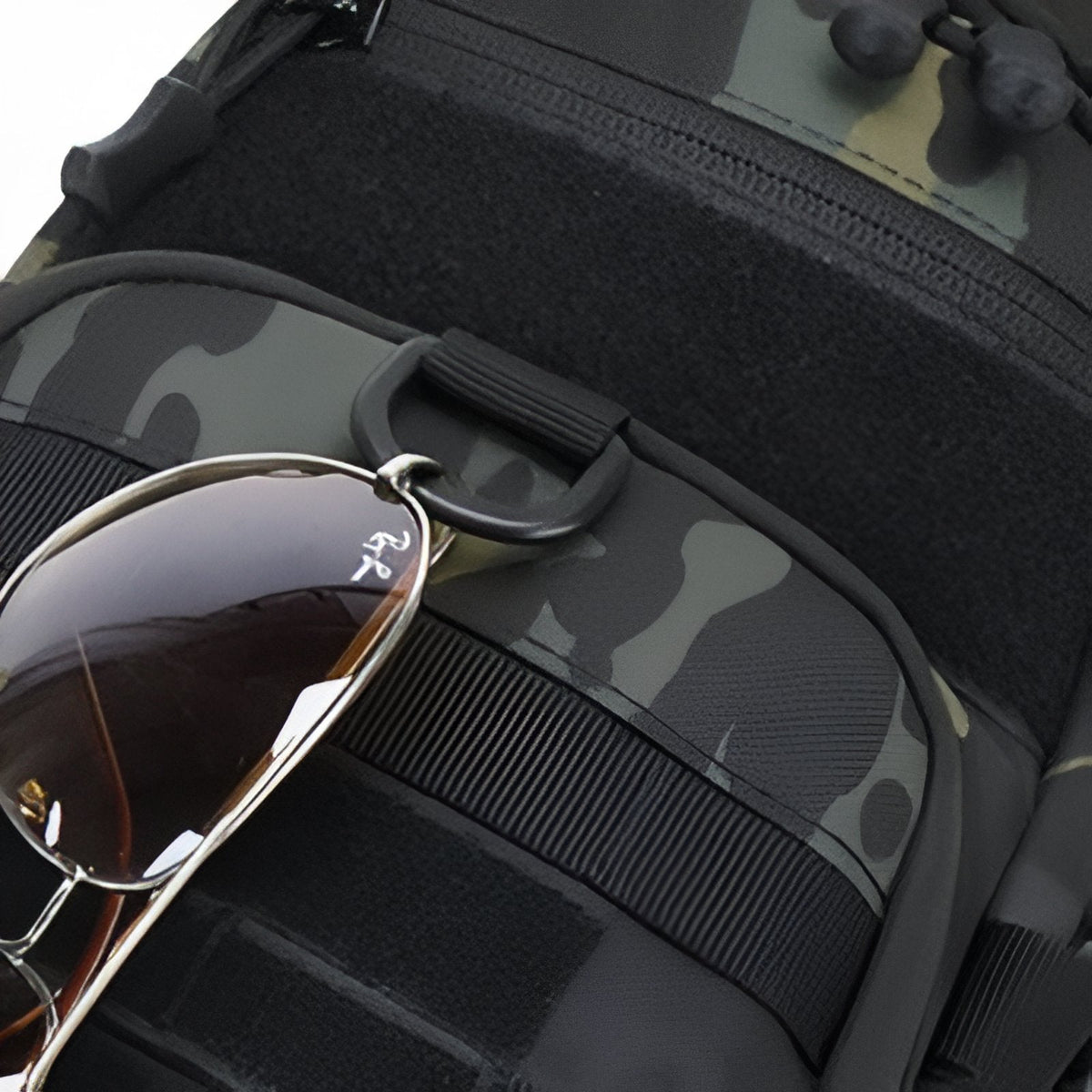 Sunglasses hooked into the webbing on the bag's front