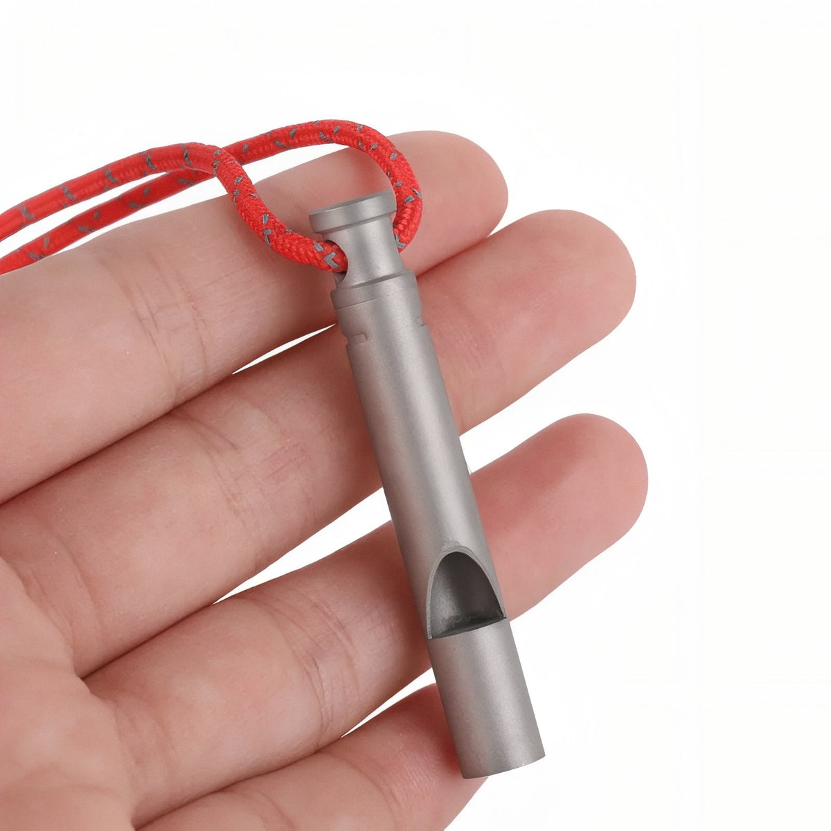 Titanium whistle on a red cord resting in an open hand