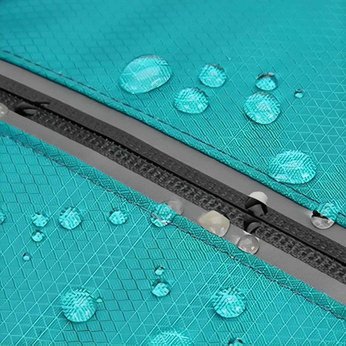Water droplets beading on the turquoise nylon beside a zip