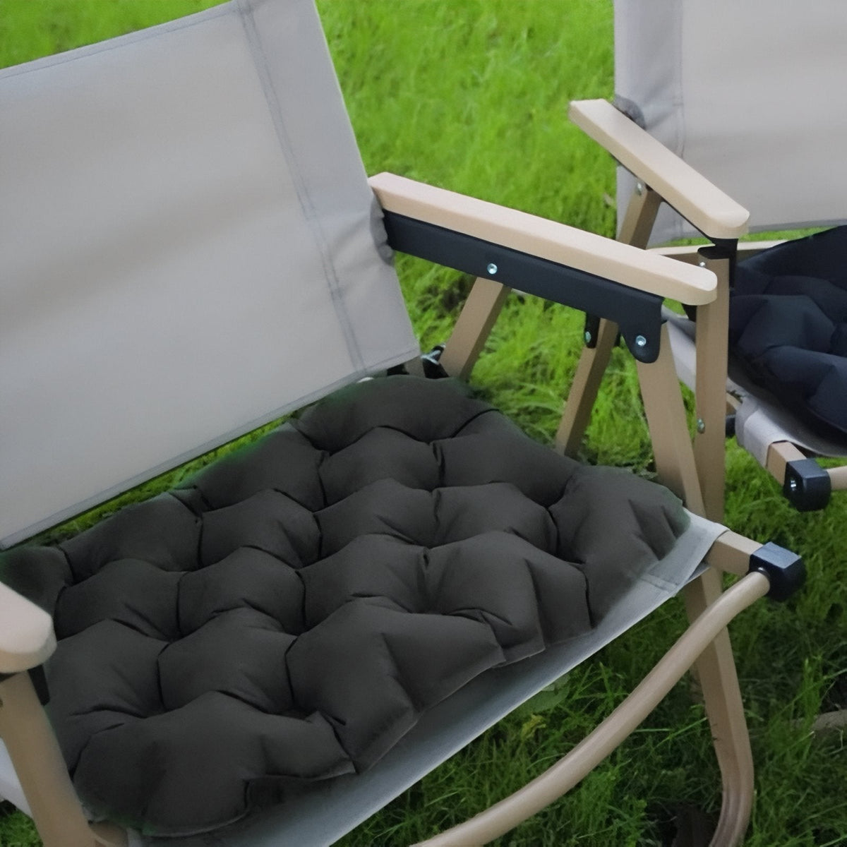The charcoal seat cushion on a folding camp chair