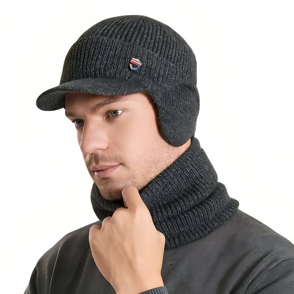 Man wearing the dark grey knit winter hat with brim and ear flaps and the matching neck warmer