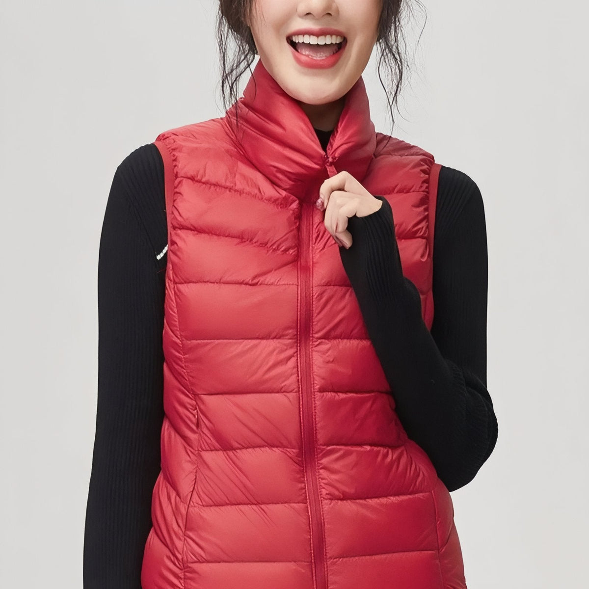 Smiling woman wearing the red quilted vest over a black top