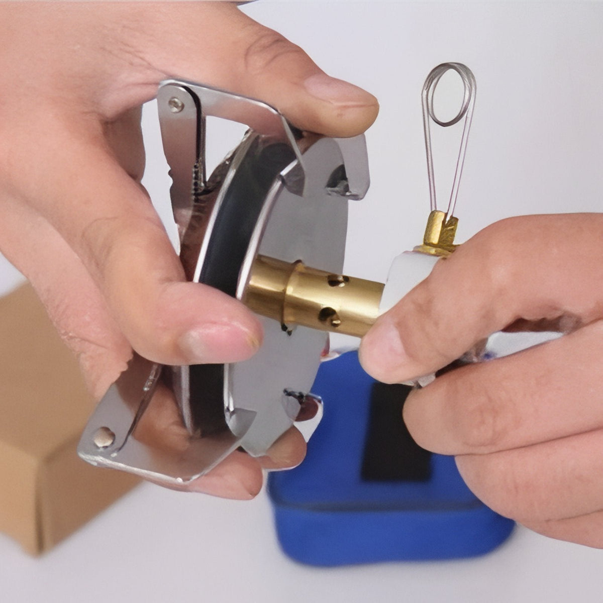 Hands screwing the brass valve stem into the stove's burner head