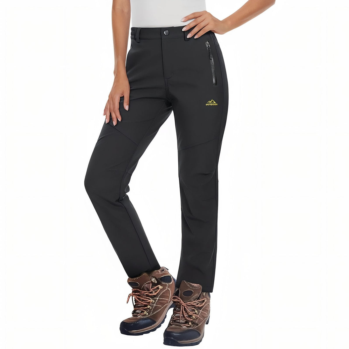 Woman wearing the black fleece-lined softshell hiking trousers with brown hiking boots, front view