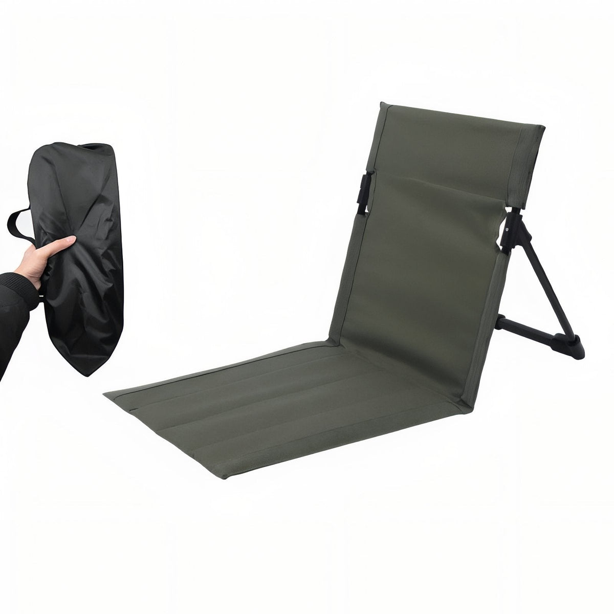 Olive green folding ground chair set up, beside its black storage bag held by a hand