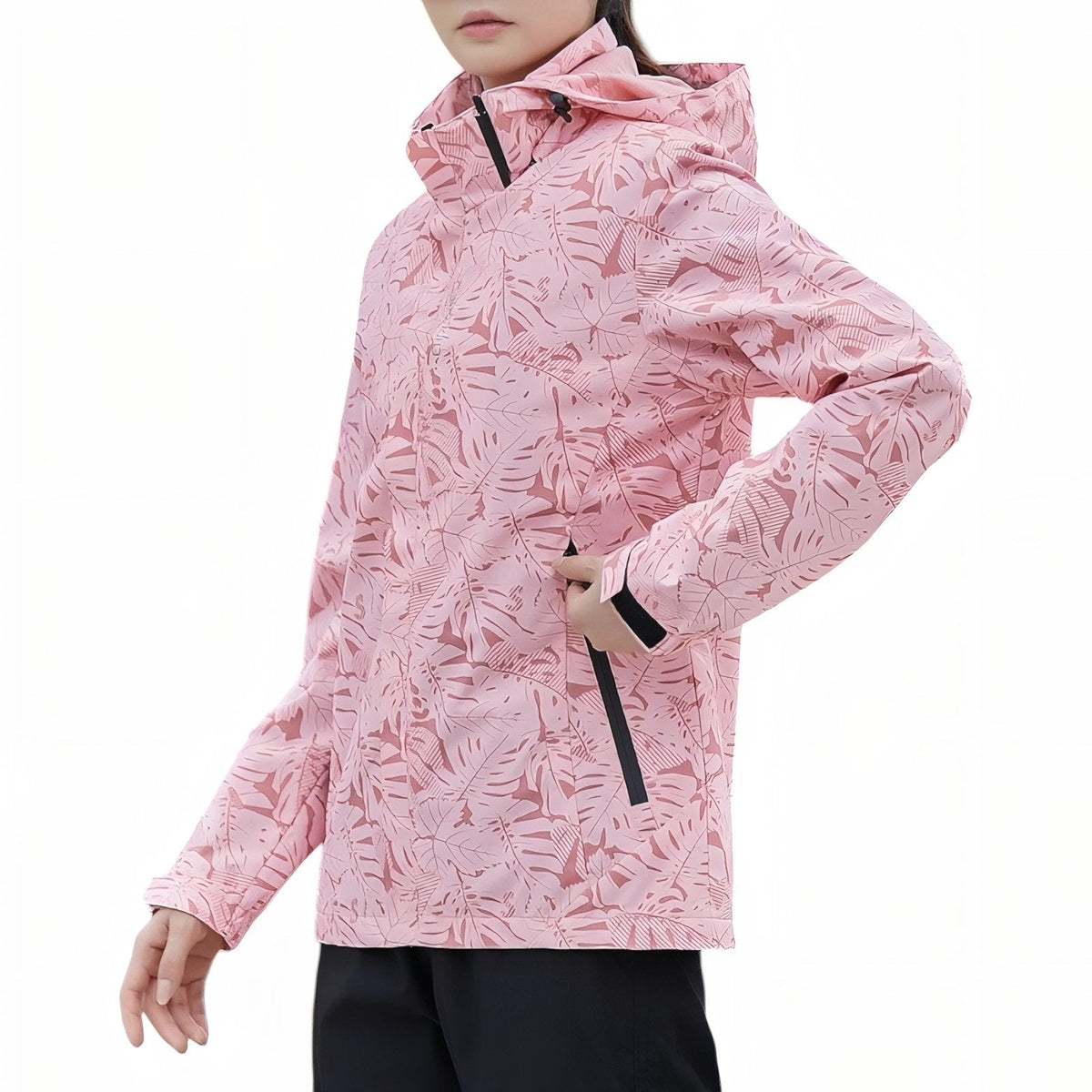 Woman wearing the pink leaf-print hooded hiking jacket zipped up, side view