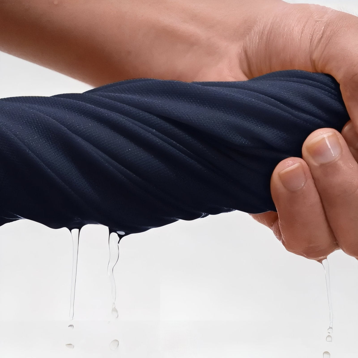 Hand stretching the navy knit fabric with water running off it