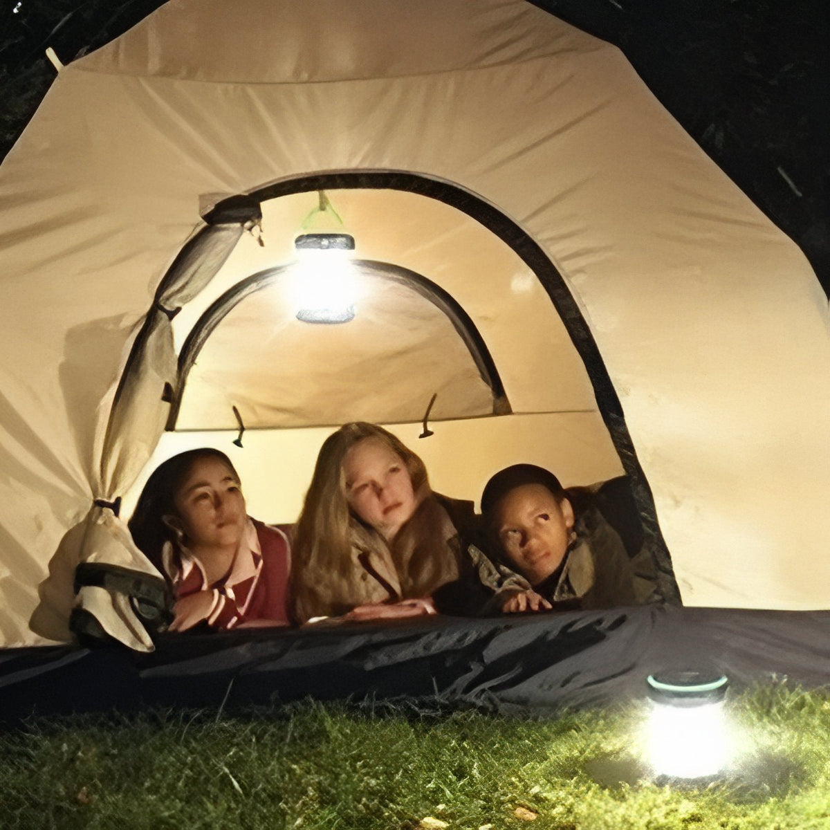 A tent at night lit from inside by the lantern, children looking out