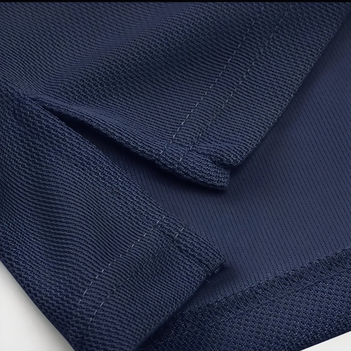 Close-up of the navy polo's split side hem