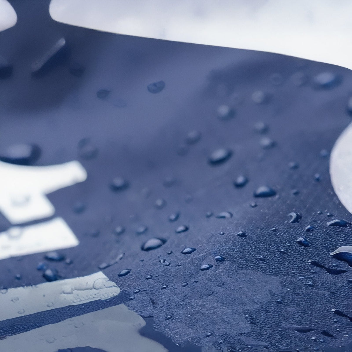 Close-up of water droplets beading on the navy shell fabric of the sleeping bag