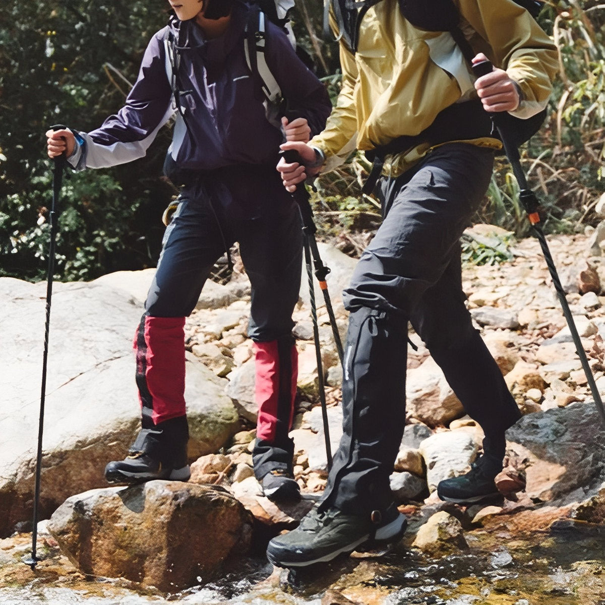 Two walkers crossing a stream with the trekking poles