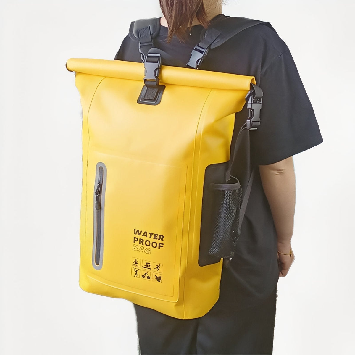 Person wearing the yellow roll-top backpack, seen from behind at an angle