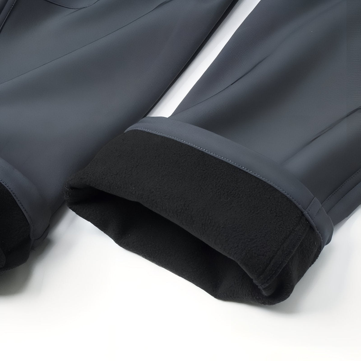 Turned-up hem of the slate grey trousers showing the black fleece lining