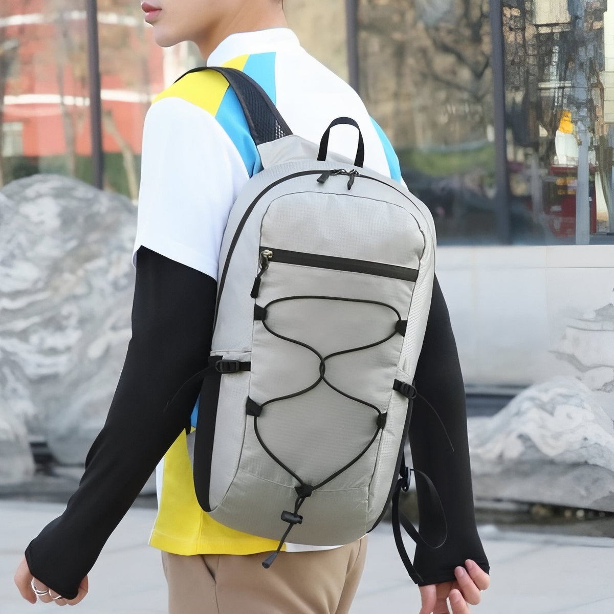 Person seen from behind wearing the light grey packable daypack on both shoulders