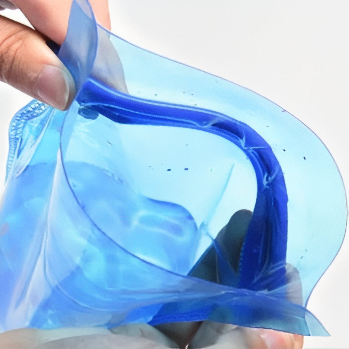 Hand holding the slide-top opening of the bladder wide open