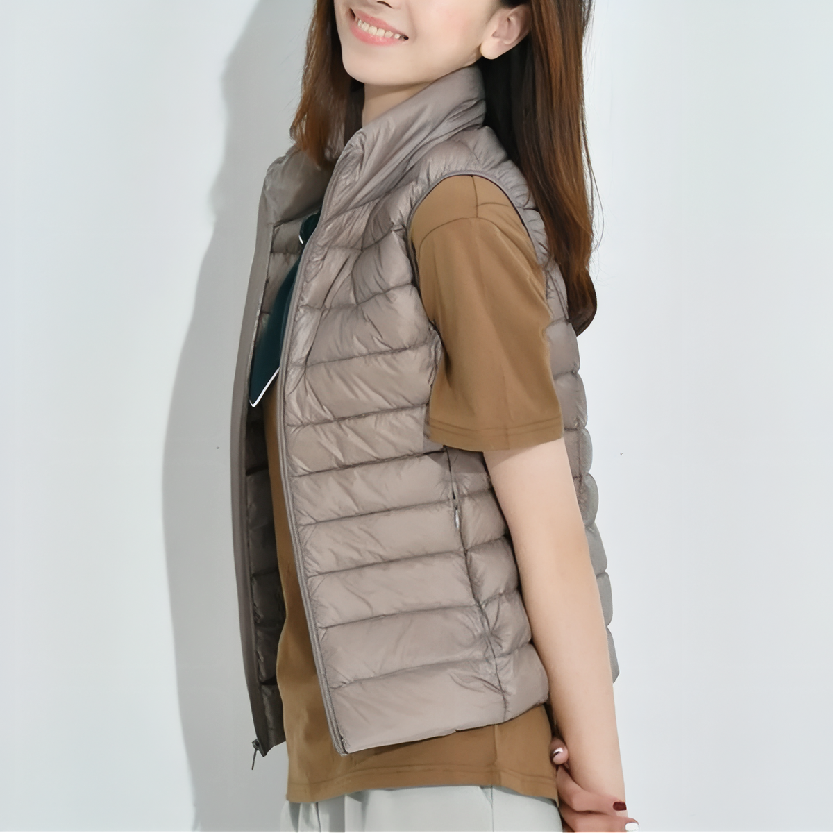 Woman wearing the taupe quilted vest over a brown T-shirt