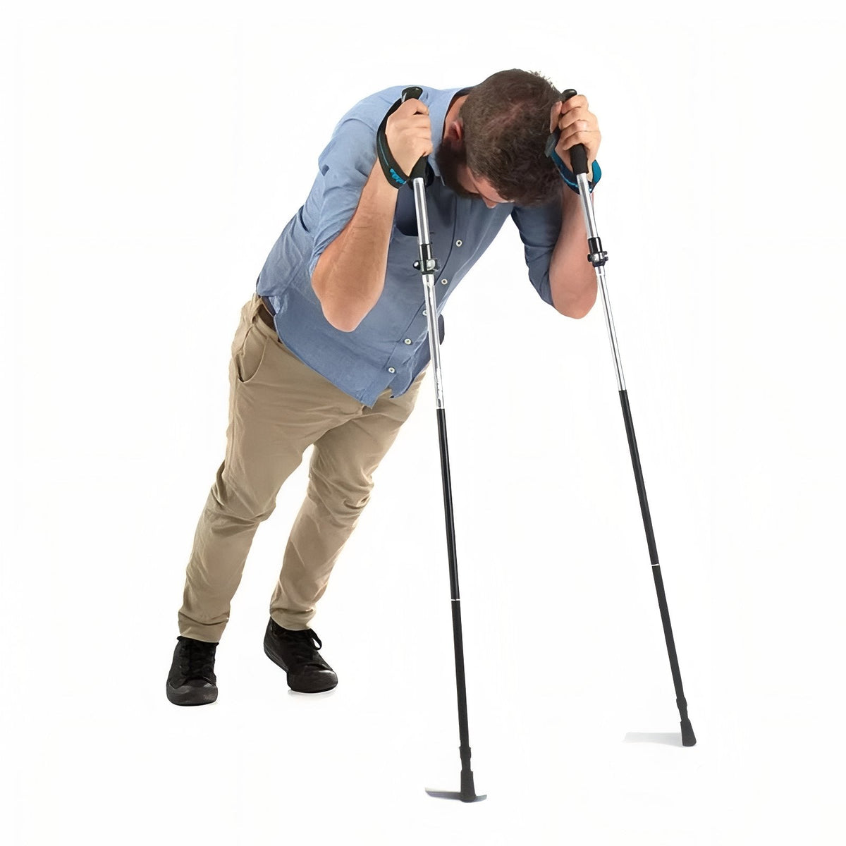 Man leaning on two silver and black trekking poles, catching his breath