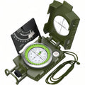 Army green sighting compass open on a white background, clinometer raised, lanyard coiled beside it