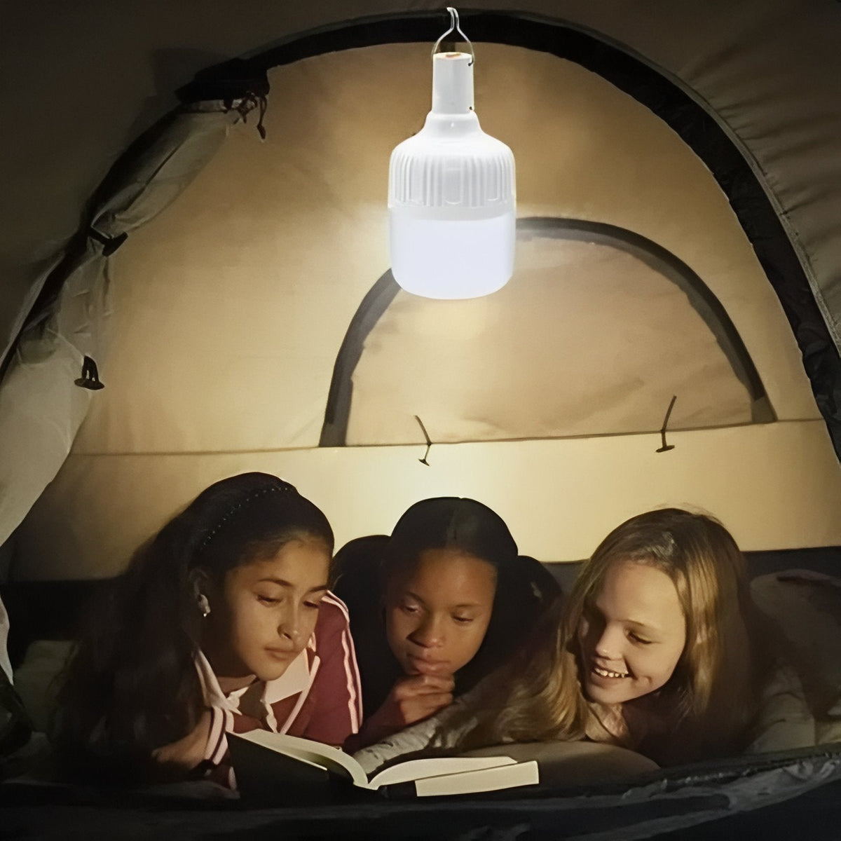 Three children reading in a tent under the hanging LED bulb lantern