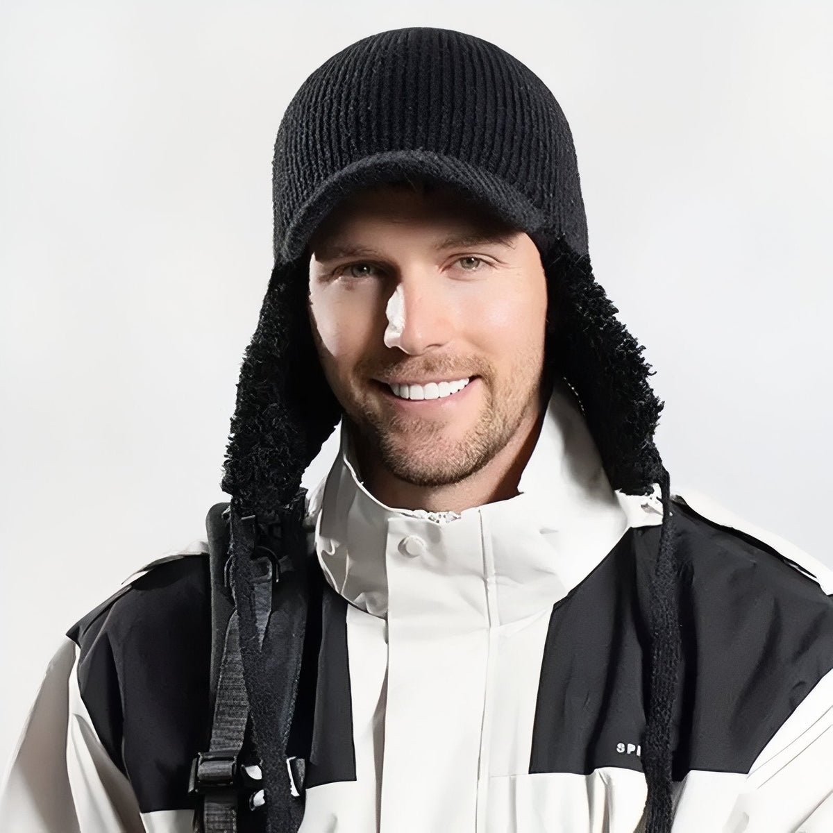 Man wearing the black trapper hat with the ear flaps down