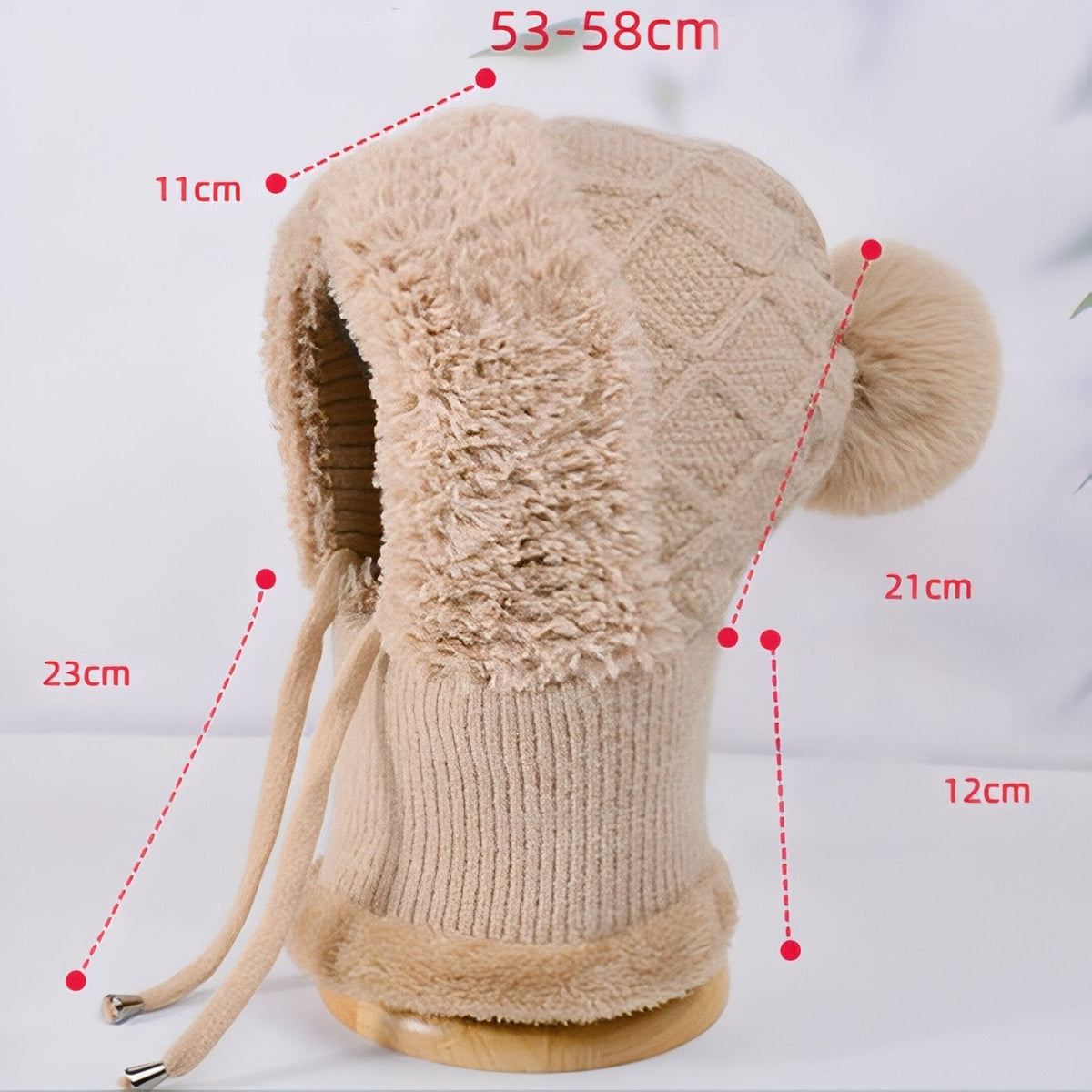 Brown balaclava hood on a stand with measurements marked: head circumference 53-58 cm and the neck and cord lengths in cm