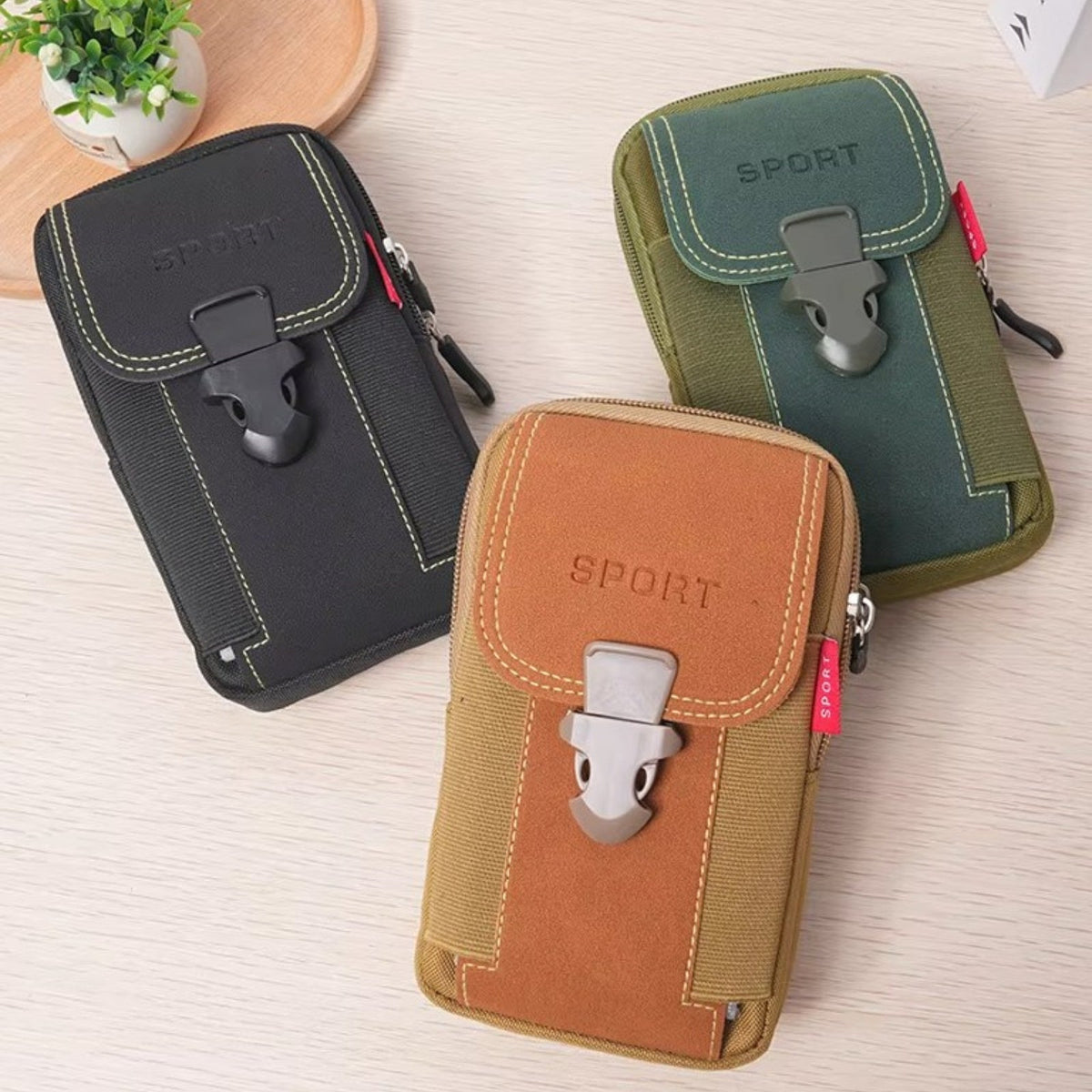 Black, olive green and brown vertical belt pouches on a table
