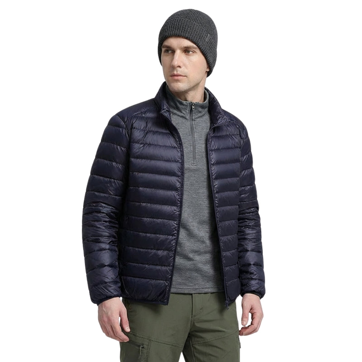 Man wearing the navy blue lightweight puffer jacket open over a grey zip-neck top, front view